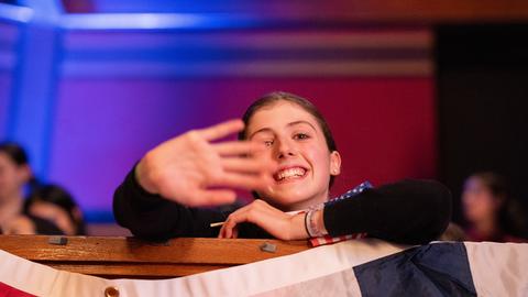 A girl waving at the camera. 